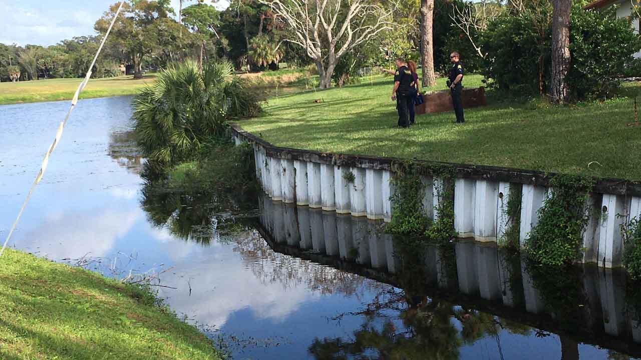 St. Petersburg Police officers standing near a retention pond where a 3-year-old boy reported missing Sunday morning was found. The child later died at an area hospital. (Adria Iraheta/Spectrum Bay News 9)