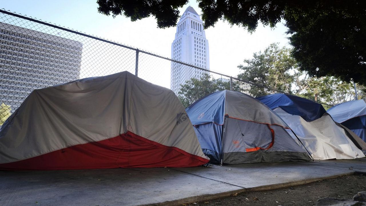 Los Angeles City Hall behind a homeless tent encampment along a street in downtown Los Angeles. (AP Photo/Richard Vogel)