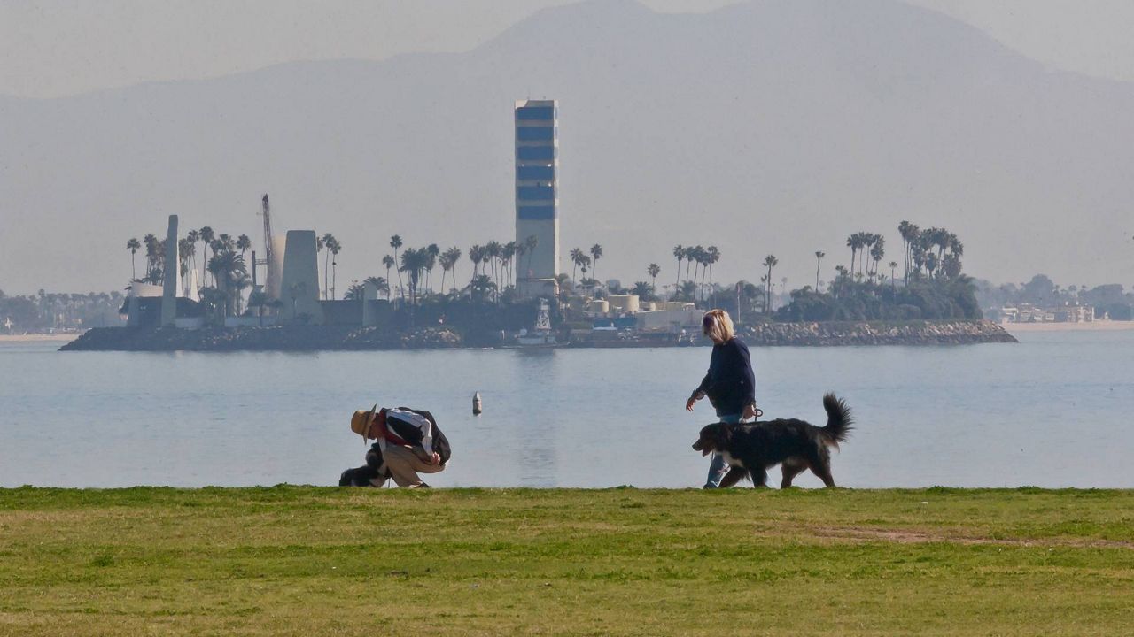 People walk on the waterfront, Jan. 14, 2015 in Long Beach, Calif. (AP Photo/Damian Dovarganes)