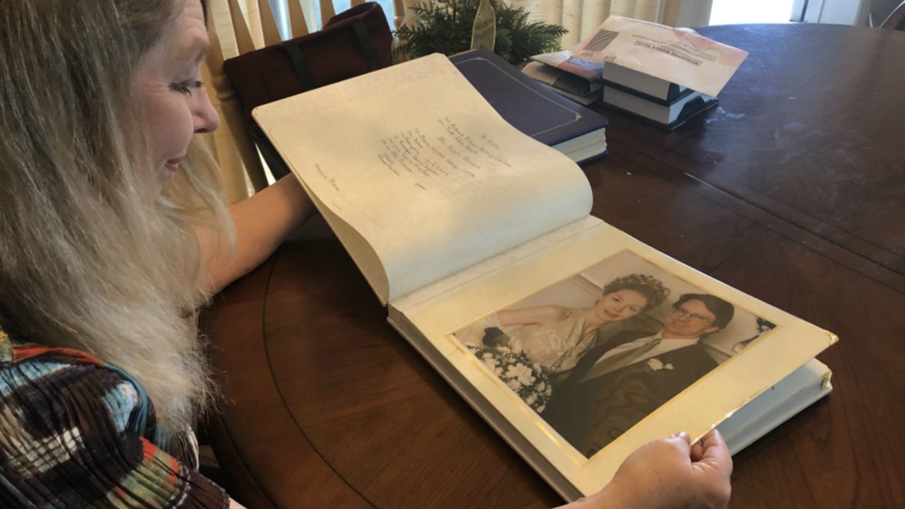 Debbie Korell, flipping through her wedding album, remembering her husband Todd. He took his life in March 2010 at the Sunshine Skyway Bridge. (Ashley Paul/Spectrum Bay News 9)
