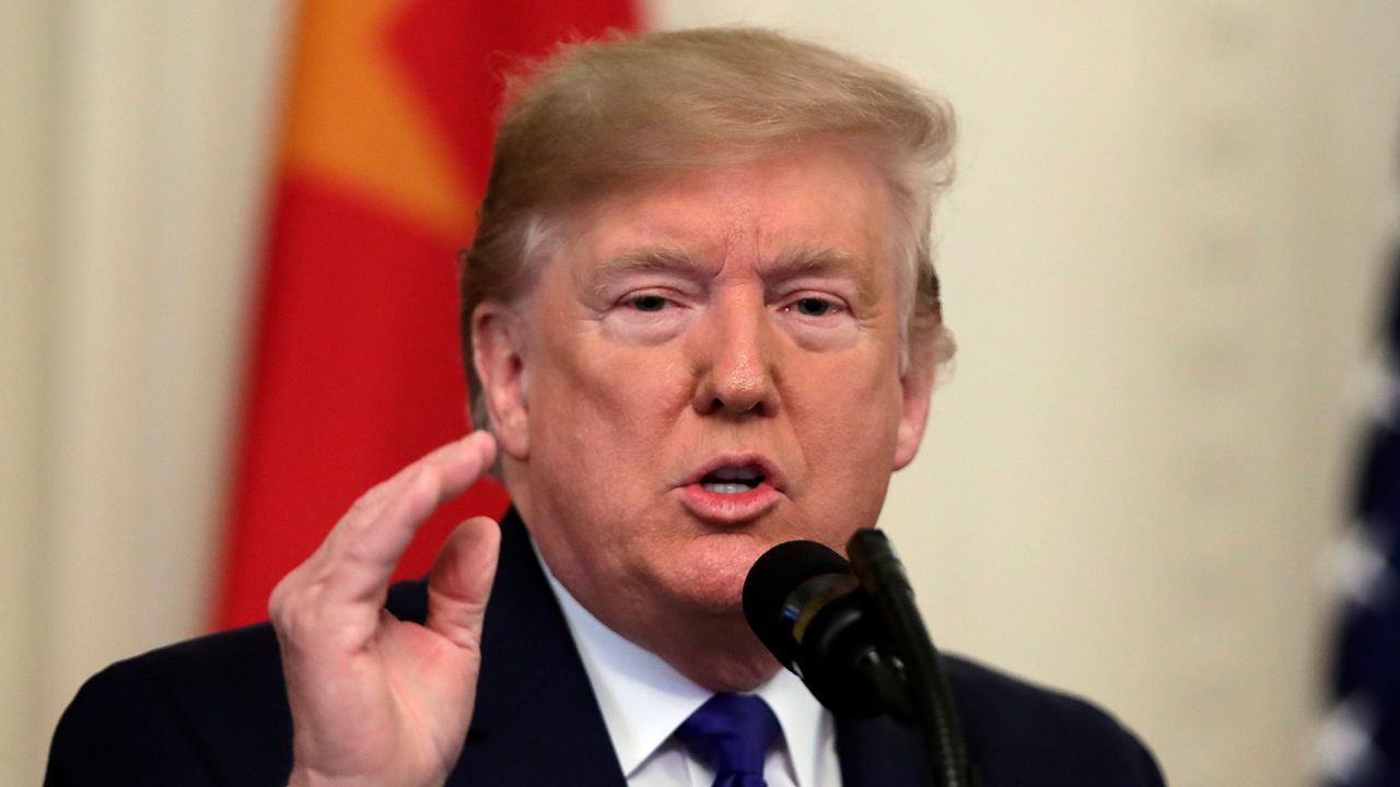 President Donald Trump, wearing a black suit jacket, a white dress shirt, and a blue tie, speaks in the East Room of the White House on January 15, 2020.