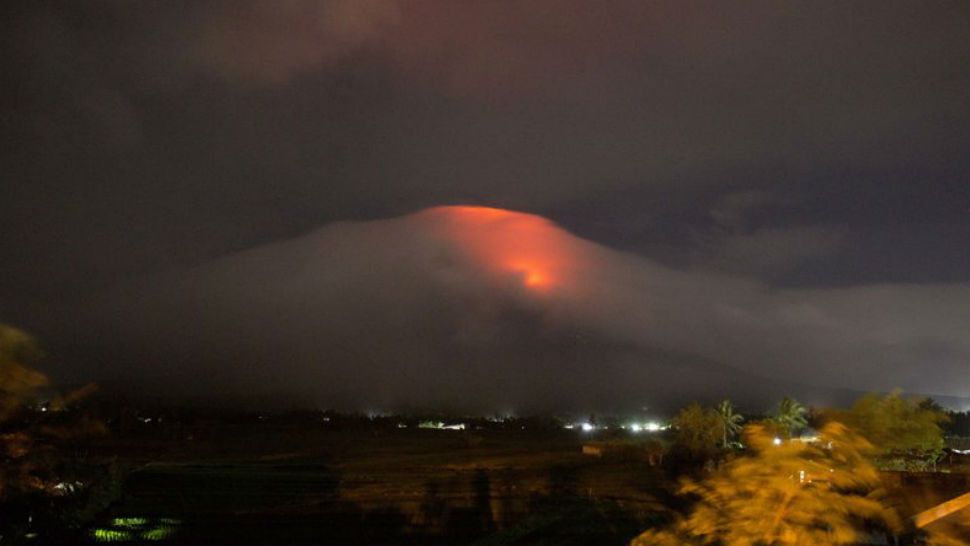 In this Sunday, Jan. 14, 2018, photo provided by Earl Recamunda, an orange glow is seen at the cloud-shrouded crater of Mayon volcano at Legazpi city, Albay province, about 340 kilometers (210 miles) southeast of Manila, Philippines. The Philippines’ most active volcano rumbled back to life Sunday with lava rising to its crater in a gentle eruption that has prompted authorities to evacuate thousands of villagers. (Earl Recamunda via AP)  