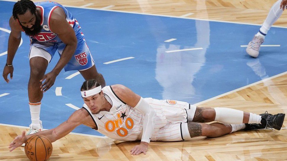 Brooklyn Nets guard James Harden (13) and Orlando Magic forward Aaron Gordon (00) vie for a loose ball during the first half of an NBA basketball game, Saturday, Jan. 16, 2021, in New York. (AP Photo/Mary Altaffer)