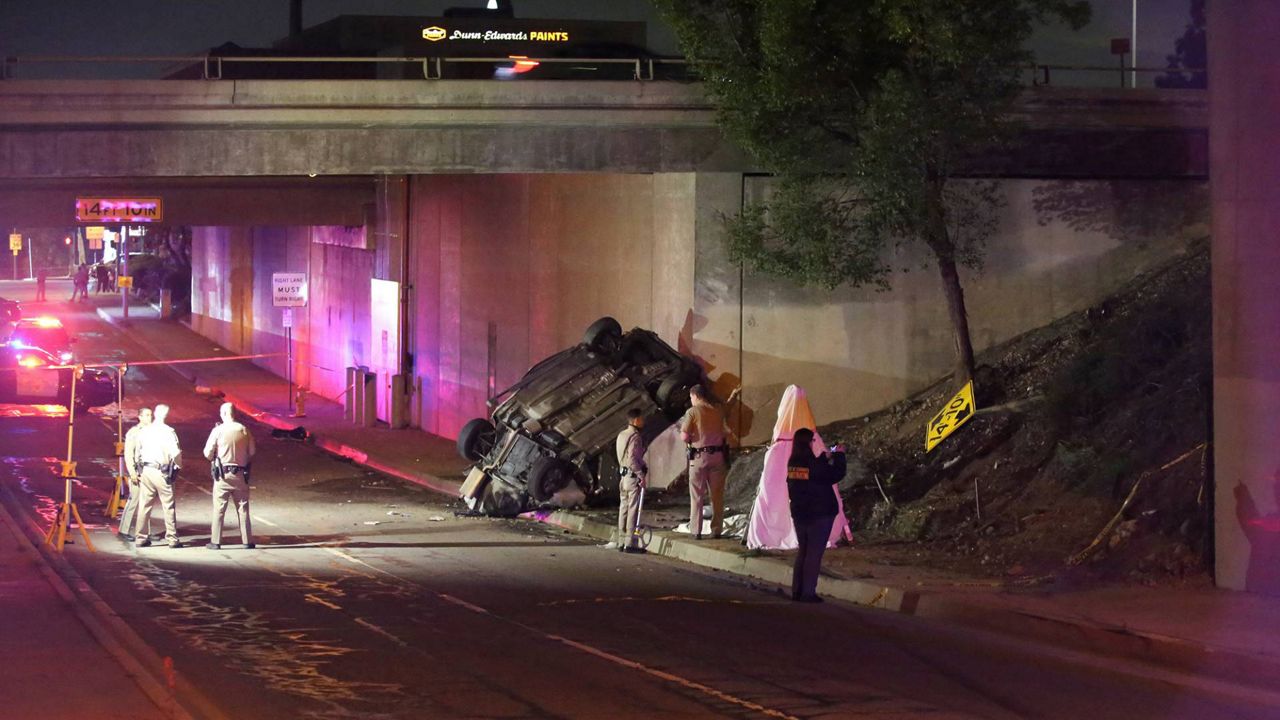 California Highway Patrol officers work at the scene of a fatal accident after the vehicle plunged off an elevated section of Interstate 210 landing below on Michillinda Ave., just south of Foothill Blvd., in Pasadena, Calif., late Sunday. (AP Photo/James Carbone)