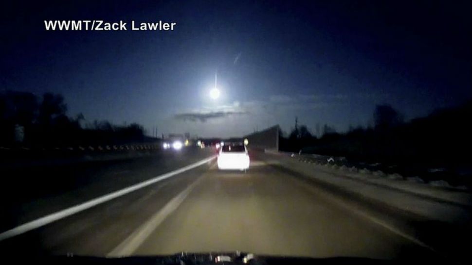 In this late Tuesday, Jan. 16, 2018, image made from dashcam video, a brightly lit object falls from the sky above a highway in the southern Michigan skyline. (Zack Lawler/WWMT via AP)