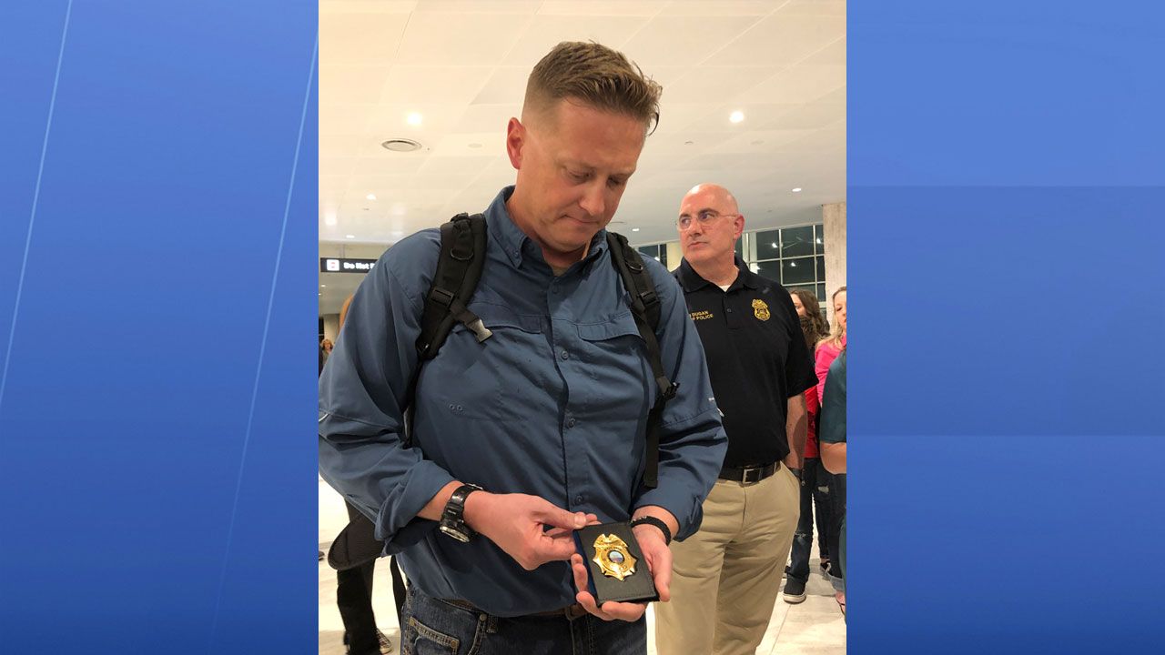 Lieutenant Travis Maus was presented with his new badge by Tampa Police Chief Brian Dugan at Tampa International Airport upon his return from a military deployment overseas. (Laurie Davison/Spectrum Bay News 9)