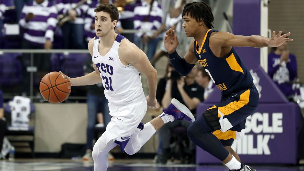 In this Jan. 15, 2019, photo, TCU guard Owen Aschieris (31) moves the ball up court as West Virginia's Trey Doomes (0) defends during an NCAA college basketball game in Fort Worth, Texas. TCU walk-on player Aschieris was sitting in a team meeting when a university police officer walked in and asked to speak to him. "I was racking my brain to think about what I might have done wrong in the past of my entire life," Aschieris said. "It was crazy." (AP Photo/Tony Gutierrez)