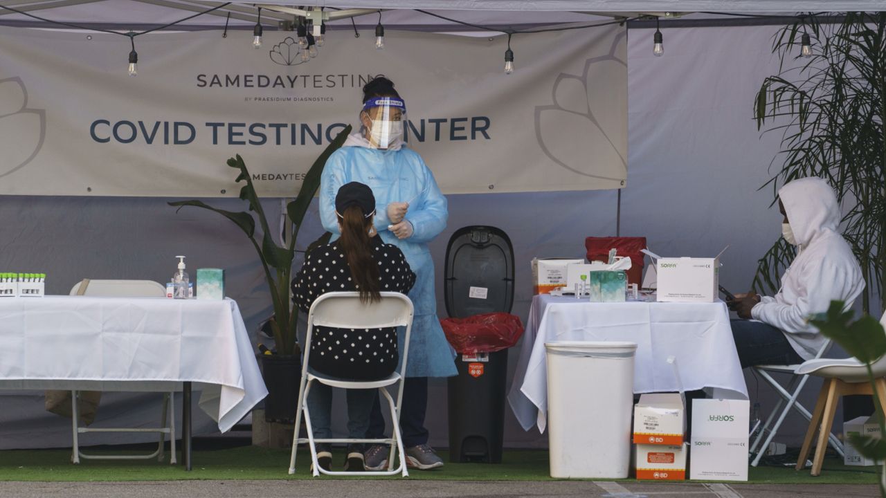 A mid-turbinate nasal swab PCR test is administered at a same-day coronavirus testing site in Los Angeles on Tuesday, Jan. 5, 2021. (AP Photo/Damian Dovarganes)