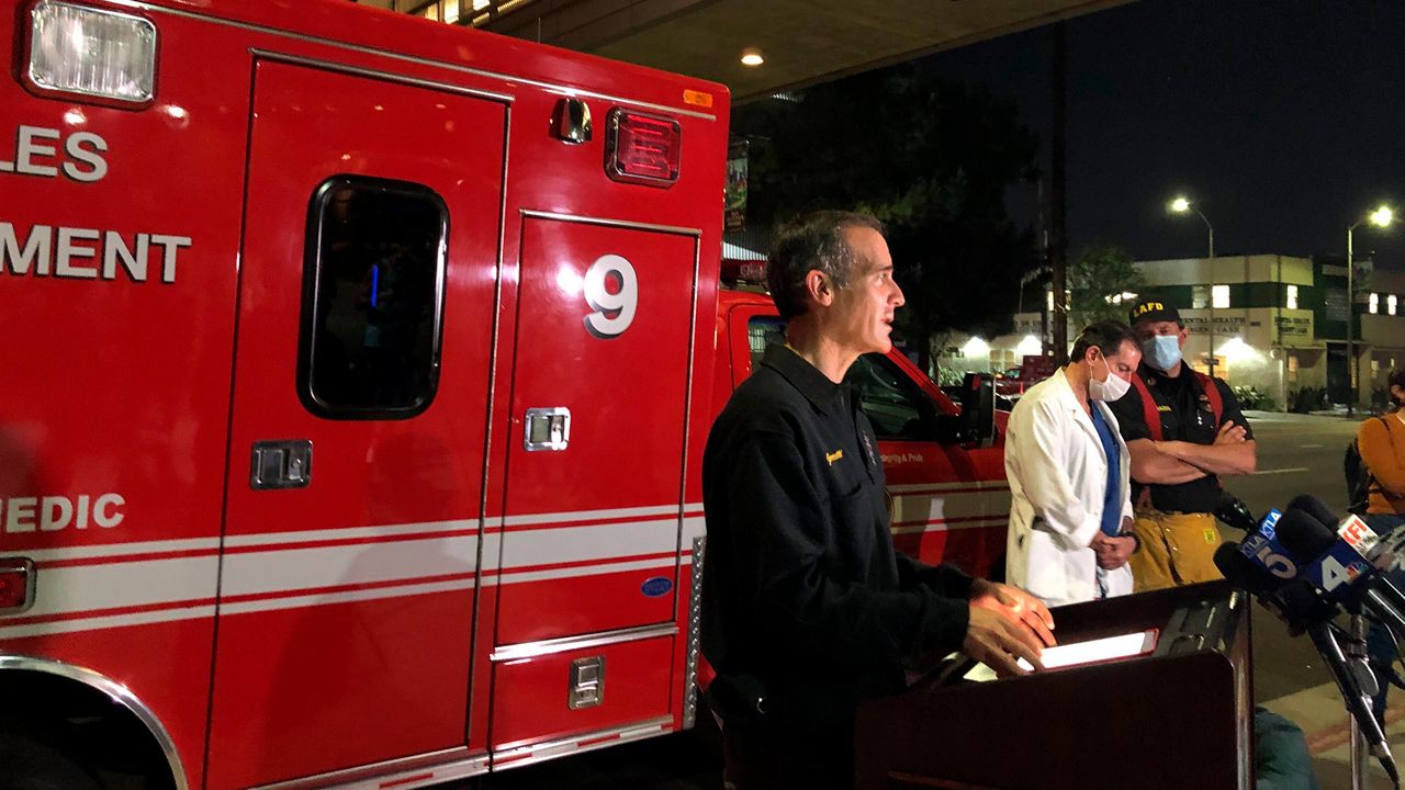 Los Angeles Mayor Eric Garcetti, standing next to Engine 9, updates the media on the conditions of multiple Los Angeles Fire Department firefighters who were injured in an explosion, May 16, 2020, in Los Angeles. (AP Photo/Stefanie Dazio)
