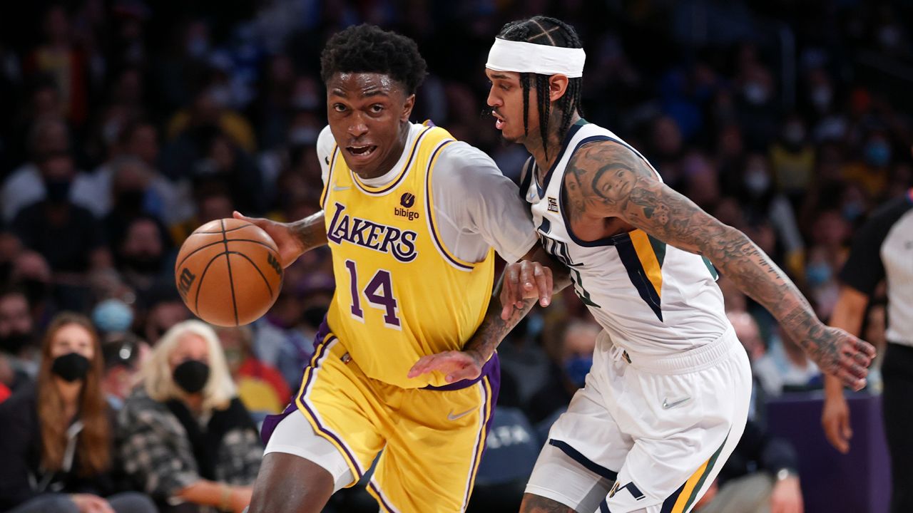 Los Angeles Lakers forward Stanley Johnson (14) drives past Utah Jazz guard Jordan Clarkson (00) during the second half of an NBA basketball game in Los Angeles, Monday, Jan. 17, 2022. (AP Photo/Ringo H.W. Chiu)