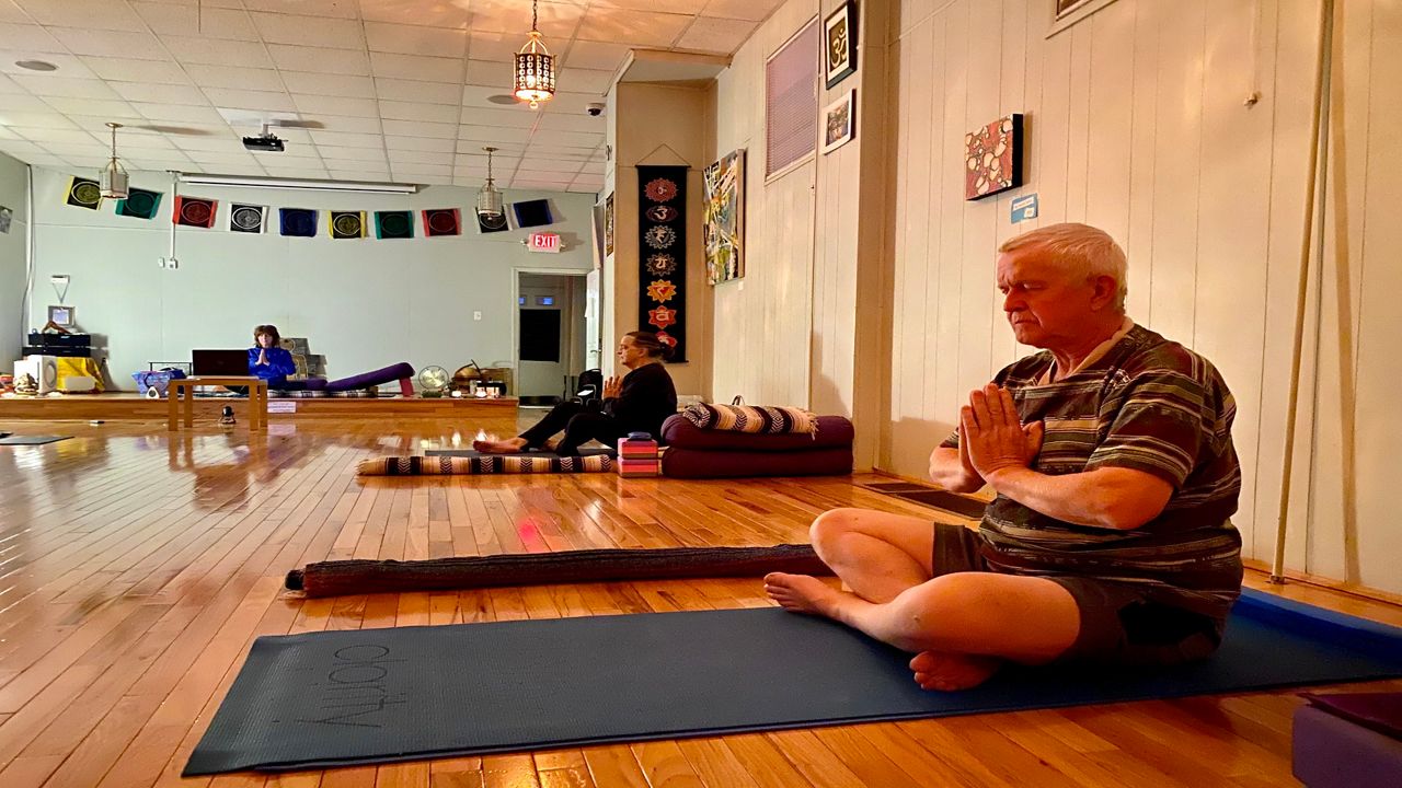 A man sits on a yoga mat