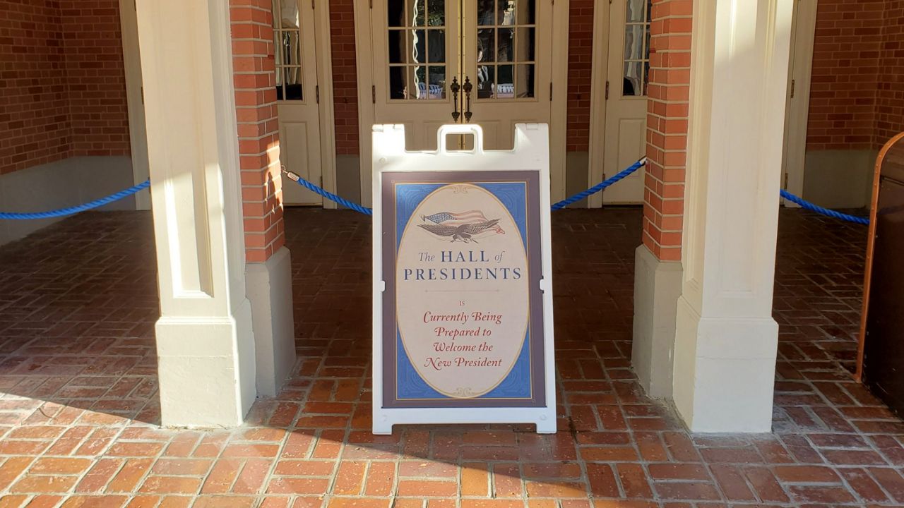 A sandwich board in front of The Hall of Presidents at Magic Kingdom says it's "currently being prepared to welcome the new president." (Ashley Carter/Spectrum News)