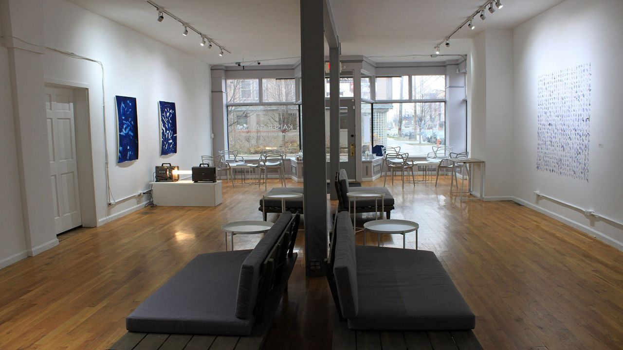 A gallery with white walls and brown wood floor