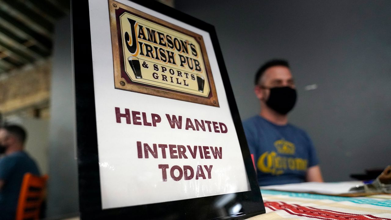 A hiring sign is placed at a booth for Jameson's Irish Pub during a job fair Wednesday, Sept. 22, 2021, in the West Hollywood section of Los Angeles. (AP Photo/Marcio Jose Sanchez)
