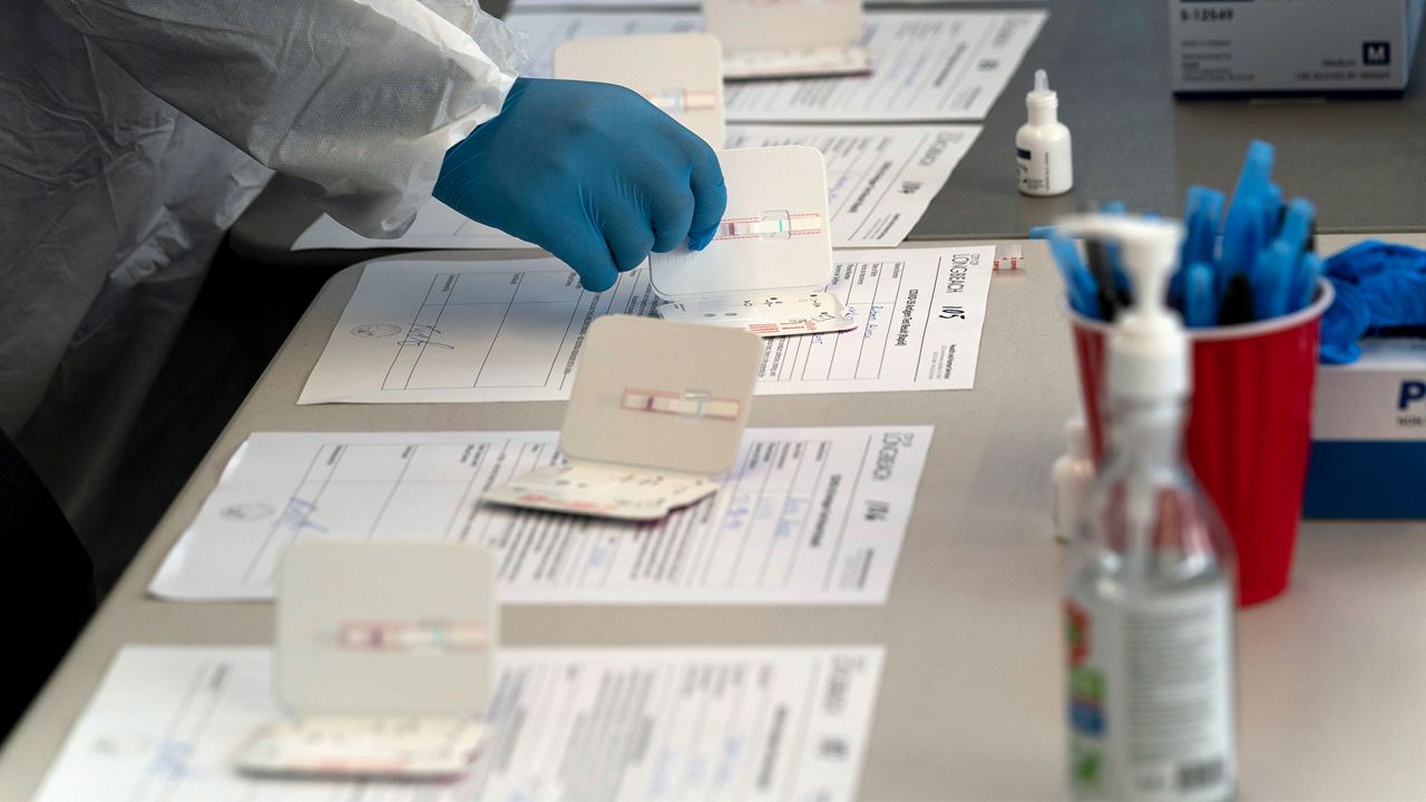 Nurse Ray Akindele processes COVID-19 rapid antigen tests at a testing site in Long Beach , Calif., Thursday, Jan. 6, 2022. (AP Photo/Jae C. Hong)