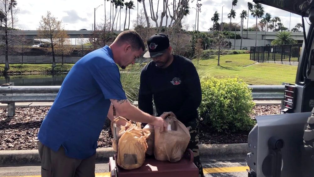 Joel Dawson, owner of Brothers N Arms BBQ, pulls out the goodies he brought for federal workers at Orlando International Airport for lunch Tuesday. (Spectrum News)