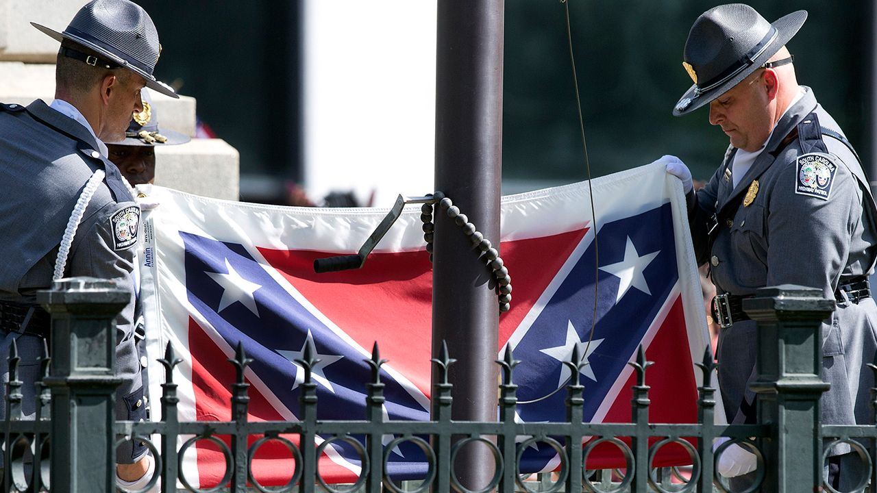 Officers folding Confederate flag