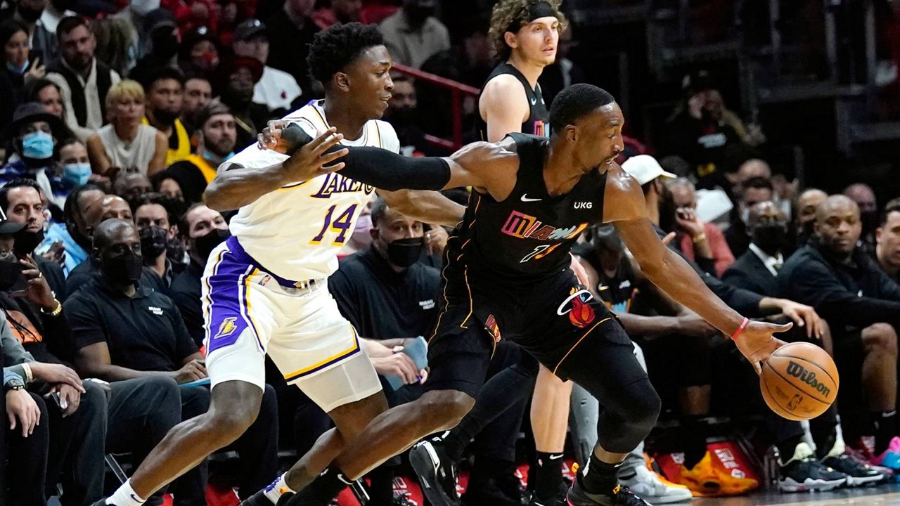 Miami Heat center Bam Adebayo (13) drives to the basket as Los Angeles Lakers forward Stanley Johnson (14) defends during the first half of an NBA basketball game, Sunday, Jan. 23, 2022, in Miami. (AP Photo/Lynne Sladky)