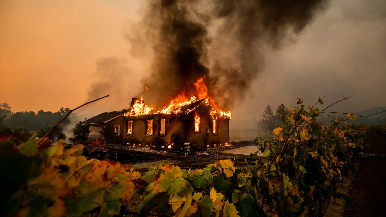 Vines surround a burning building as the Kincade Fire burns through the Jimtown community of unincorporated Sonoma County, Calif., on Oct. 24, 2019. (AP Photo/Noah Berger, File)