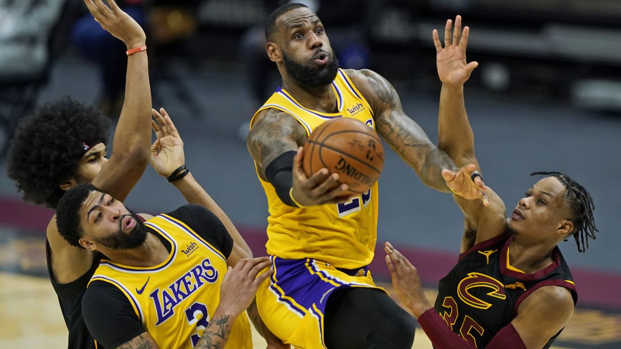 Los Angeles Lakers' LeBron James drives to the basket against Cleveland Cavaliers' Isaac Okoro, right, in the second half of an NBA basketball game, Monday, Jan. 25, 2021, in Cleveland. (AP Photo/Tony Dejak)