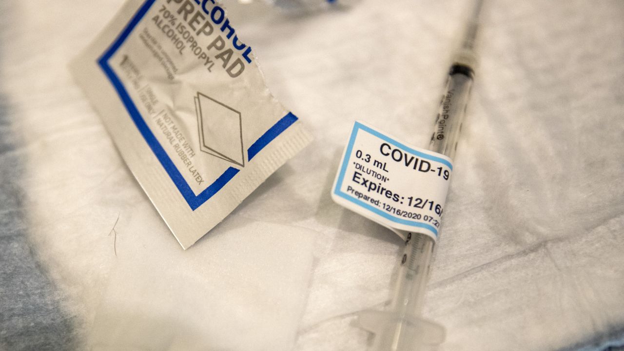 An empty syringe on a table at Ronald Reagan UCLA Medical Center after a care worker received the Covid-19 vaccine on Wednesday, Dec. 16, 2020 in Westwood, CA. (Brian van der Brug/Los Angeles Times via AP, Pool)