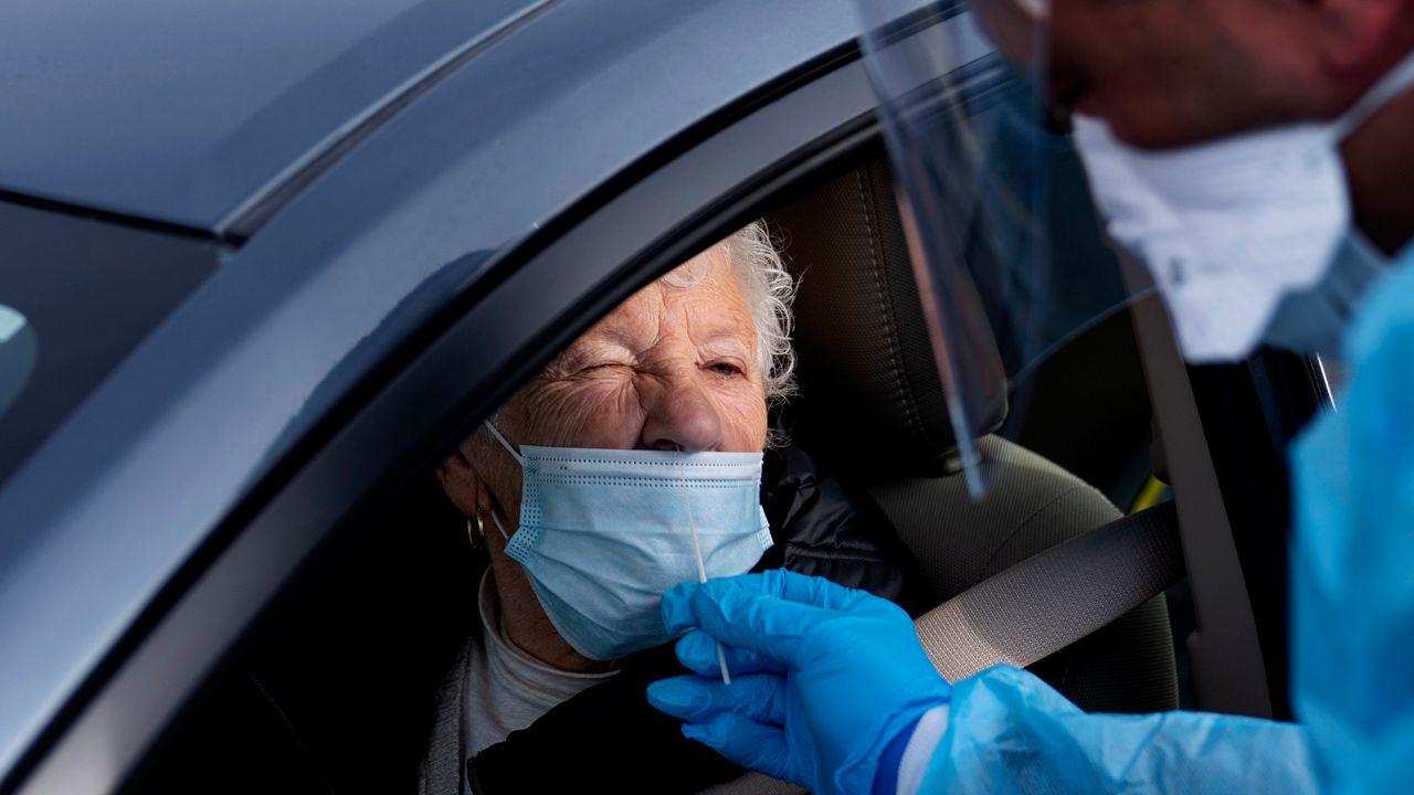 (AP Photo) Woman receives a COVID-19 test from her car.
