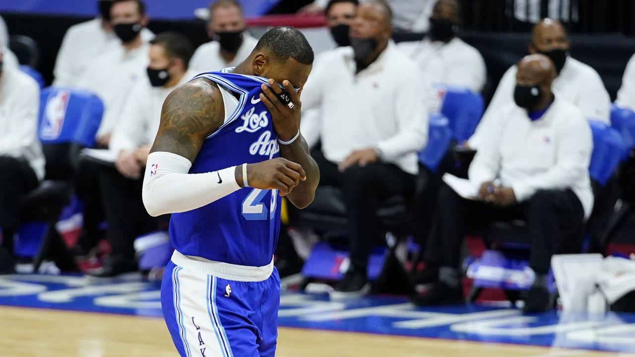 Los Angeles Lakers' LeBron James wipes his face after missing a pair of free-throws during the second half of an NBA basketball game against the Philadelphia 76ers, Wednesday, Jan. 27, 2021, in Philadelphia. (AP Photo/Matt Slocum)