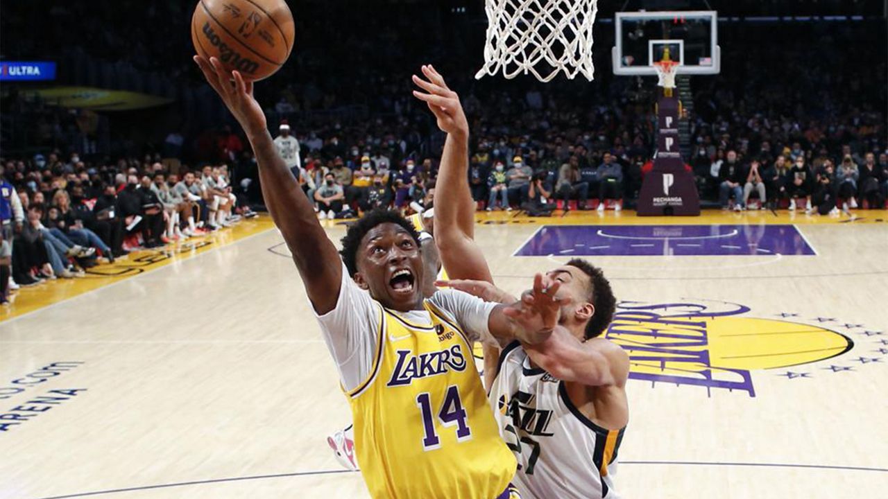 Los Angeles Lakers forward Stanley Johnson (14) goes to basket while defended by Utah Jazz center Rudy Gobert (27) during the second half of an NBA basketball game in Los Angeles, Monday, Jan. 17, 2022. The Lakers won 101-95. (AP Photo/Ringo H.W. Chiu)