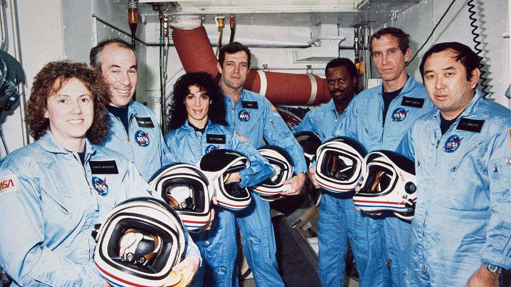 The STS-51L crew poses during training. Left to Right: Christa McAuliffe, Gregory Jarvis, Judith Resnik, Francis Scobee, Ronald McNair, Mike SMith, Ellison Onizuka. (NASA)