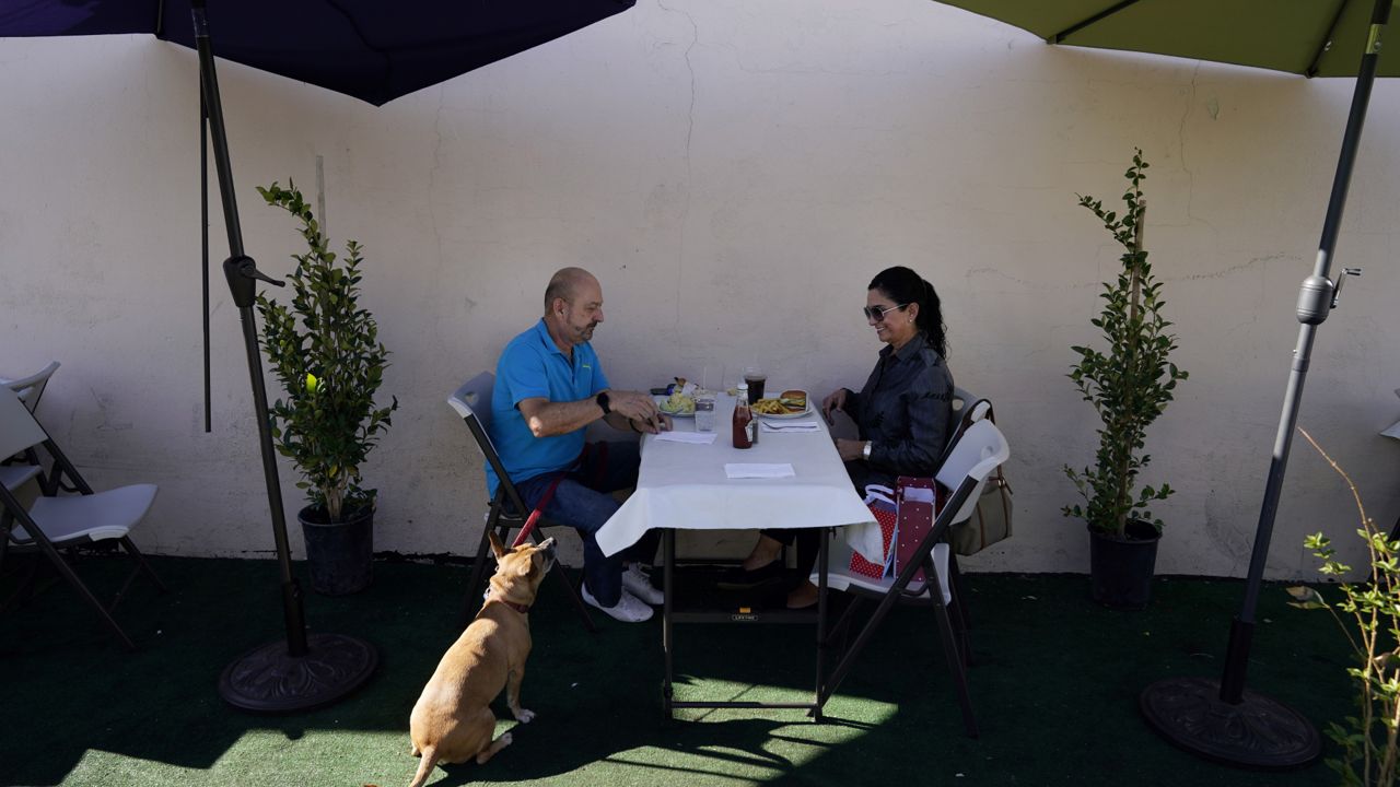 Steve Flores, left, has lunch with his cousin Carol Salter at Pie 'N Burger on Tuesday, Dec. 1, 2020, in Pasadena, Calif. (AP Photo/Marcio Jose Sanchez)