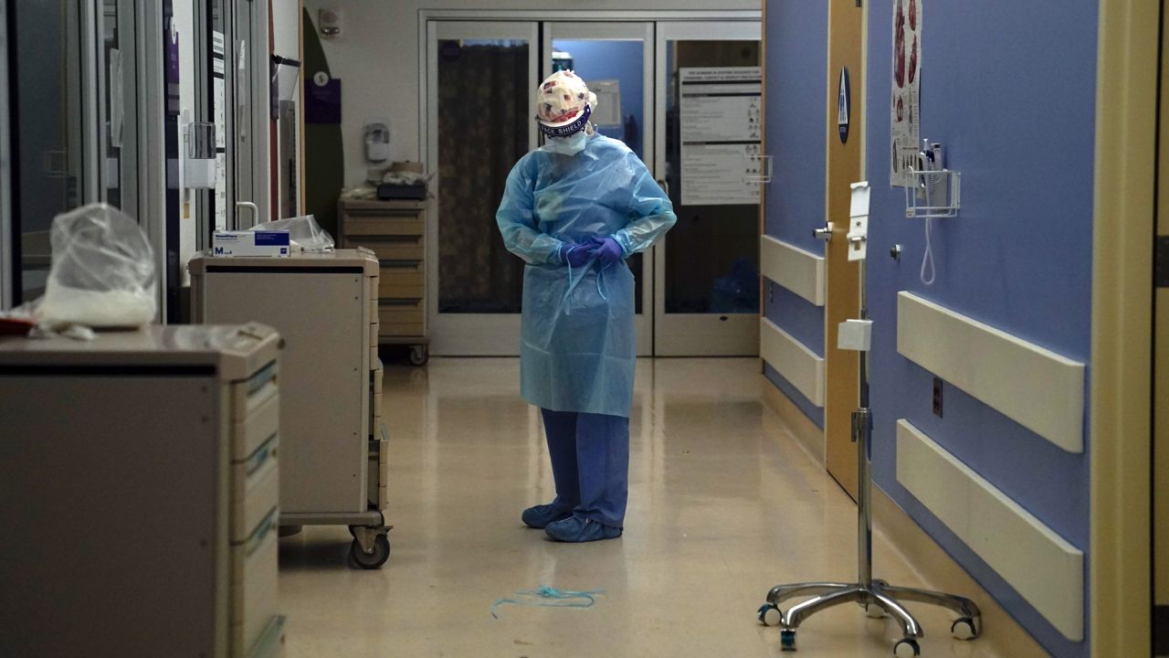 Registered nurse Anita Grohmann puts on her PPE in a COVID-19 unit at St. Joseph Hospital in Orange, Calif. Thursday, Jan. 7, 2021. (AP Photo/Jae C. Hong)
