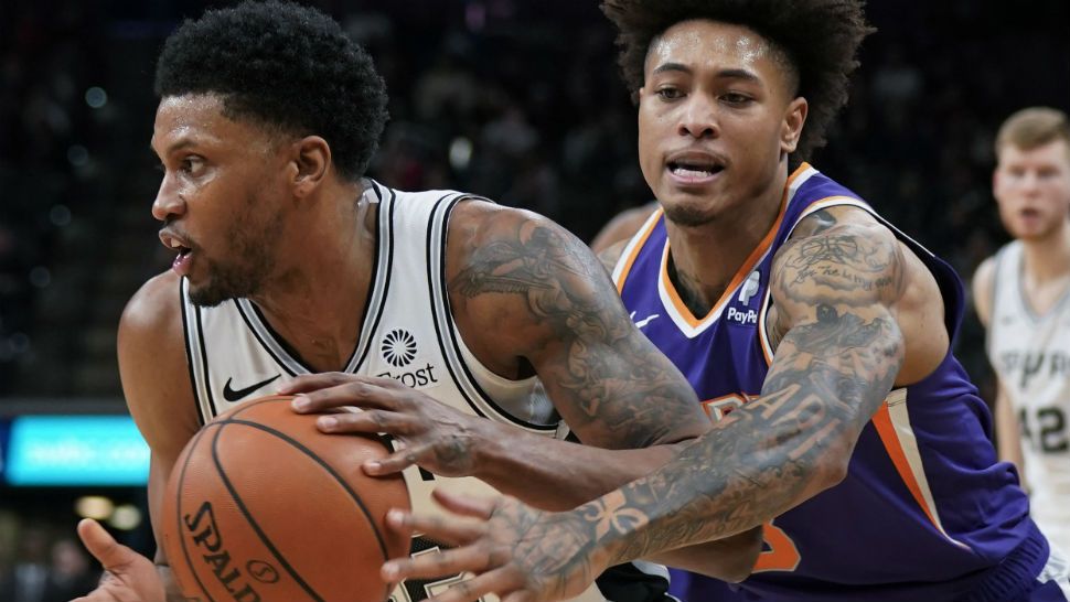 San Antonio Spurs' Rudy Gay, left, drives past Phoenix Suns' Kelly Oubre, Jr. during the second half of an NBA basketball game Tuesday, Jan. 29, 2019, in San Antonio. San Antonio won 126-124. (AP Photo/Darren Abate)