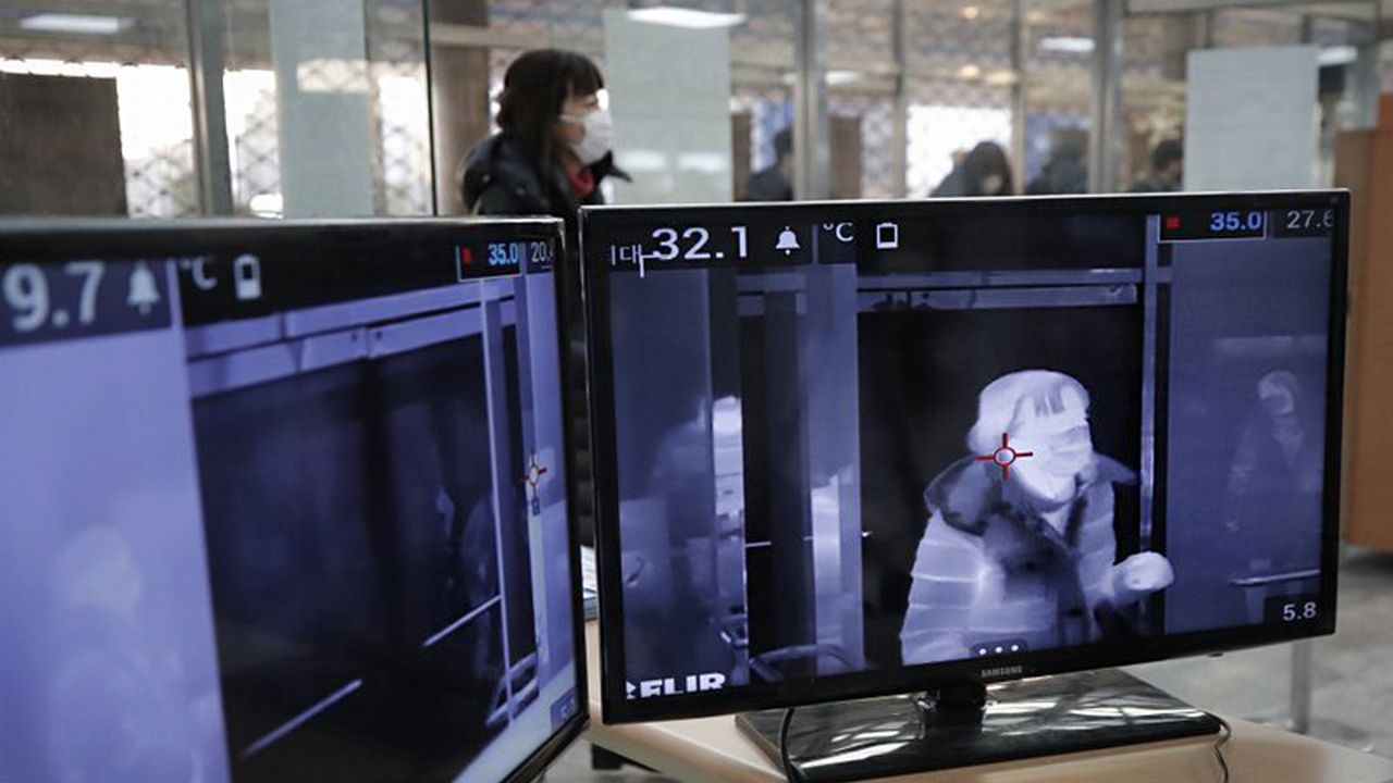A thermal camera monitor shows the body temperature of a visitor arriving at the ISU Four Continents Figure Skating Championships in Seoul, South Korea, Thursday, Feb. 6, 2020. Ten more people were sickened with a new virus aboard one of two quarantined cruise ships with some 5,400 passengers and crew aboard, health officials in Japan said Thursday, as China reported 73 more deaths and announced that the first group of patients were expected to start taking a new antiviral drug. (AP Photo/Lee Jin-man)