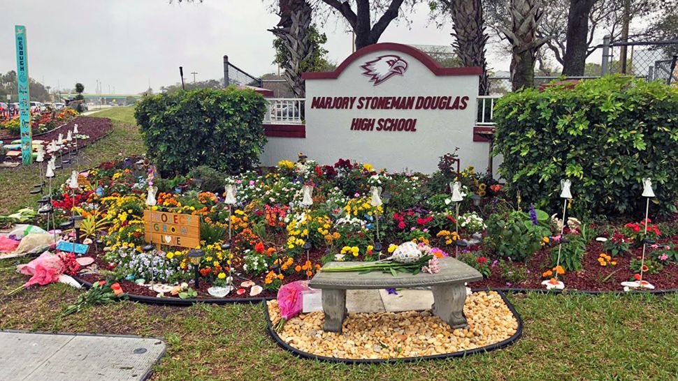 The flowers have started to pile up outside of Stoneman Douglas High School, as Thursday marks one year since the mass shooting. (Lauren Verno/Spectrum News) ‏