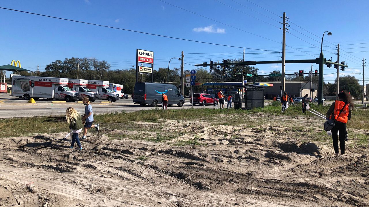 On a cool Saturday morning, dozens of people were out at the corner of Orange Blossom Trail and Gore Street, warming up by volunteering to pick up trash. (Rachael Krause/Spectrum News 13)