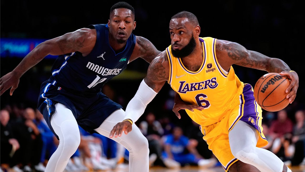 Los Angeles Lakers forward LeBron James, right, drives past Dallas Mavericks forward Dorian Finney-Smith during the first half of an NBA basketball game Tuesday, March 1, 2022, in Los Angeles. (AP Photo/Mark J. Terrill)