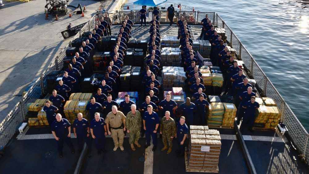Coast Guard crew members stand among 34,780 pounds of cocaine at Port Everglades. (U.S. Coast Guard)