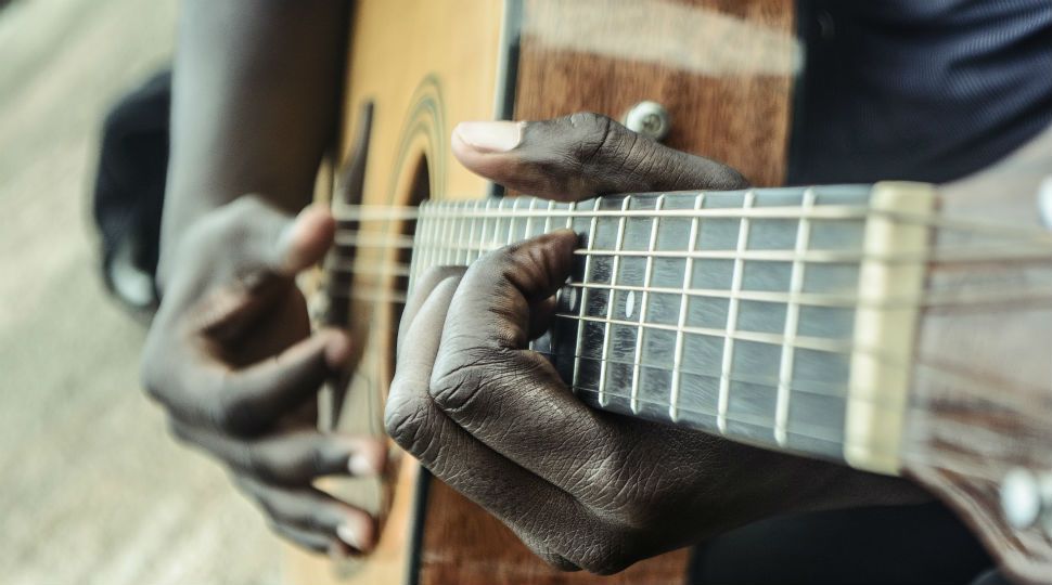 African-American hands strum a guitar (Stock image)
