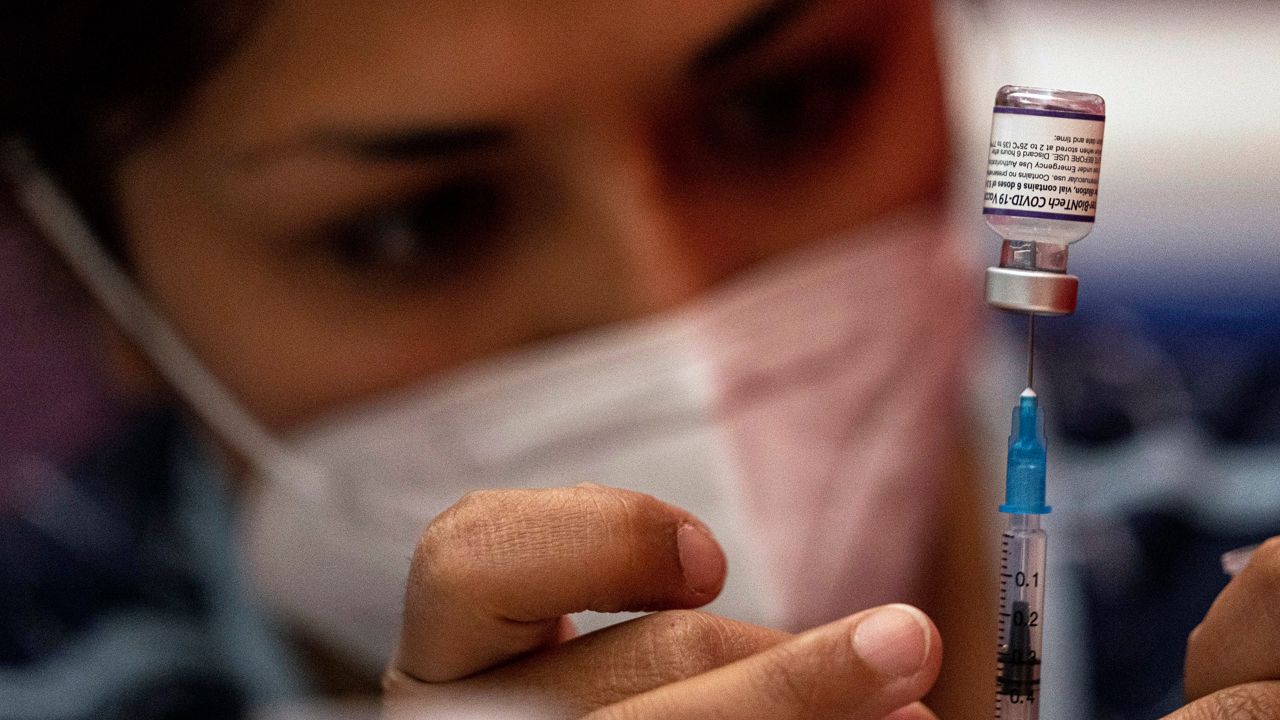 A health care worker prepares a syringe with a COVID-19 vaccine. (AP Photo)