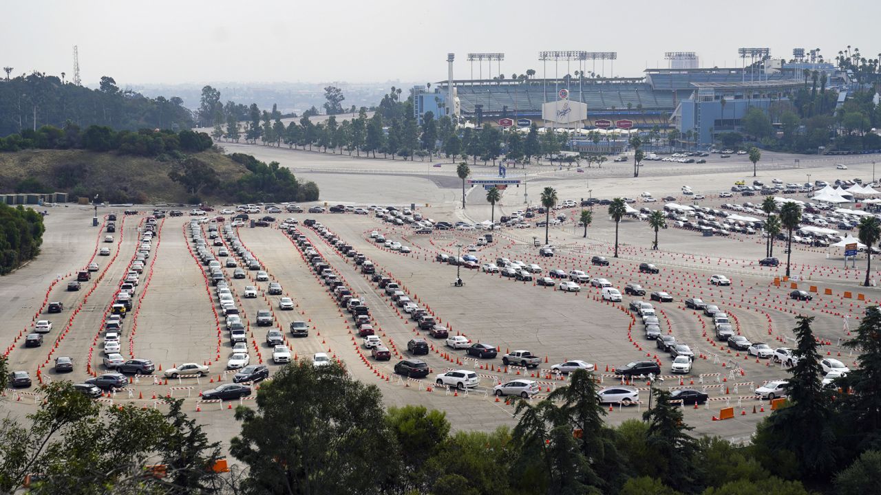 Motorists line up to receive a COVID-19 vaccine at a Los Angeles County location at Dodger Stadium in Los Angeles ,Wednesday, Feb. 10, 2021. (AP Photo/Damian Dovarganes)