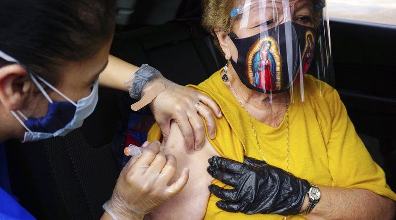 Brownsville resident Maria Flores receives an injection of the Moderna vaccine from Brownsville Independent School District (BISD) nurse Martha Demetrio, Friday, Feb. 5, 2021, in Brownsville, Texas, during a vaccination clinic at Texas Southmost College (TSC) ITEC Center. (Miguel Roberts/The Brownsville Herald via AP)