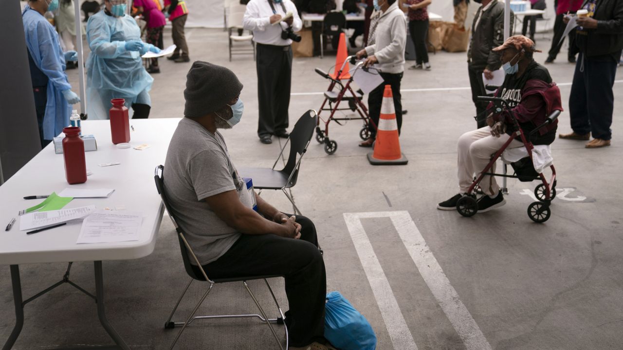Mark McNamee, a 61-year-old homeless man, waits for his COVID-19 vaccine at a vaccination site set up in the parking lot of the Los Angeles Mission in the Skid Row area of Los Angeles, Wednesday, Feb. 10, 2021. (AP Photo/Jae C. Hong)
