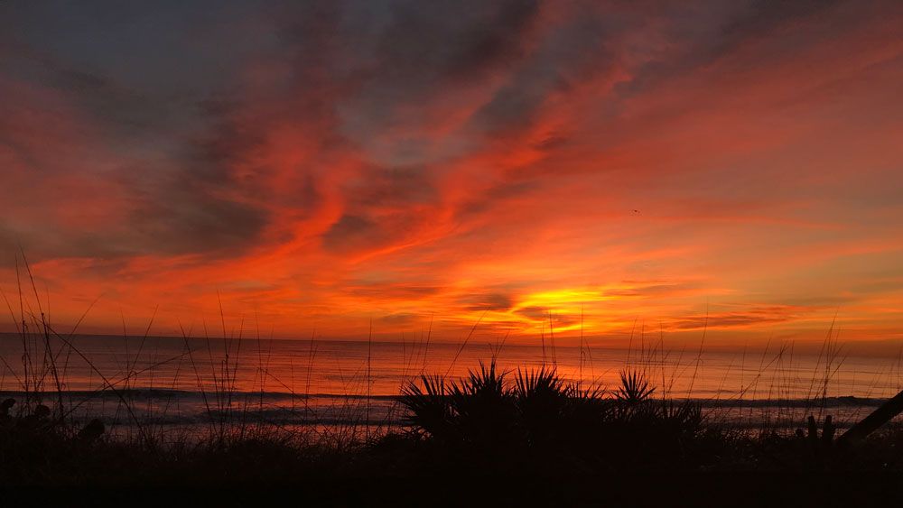 Sent via the Spectrum News 13 app: A reddish-orange sunrise in Indian Harbor Beach Saturday. (Randy Cumpston, Viewer)