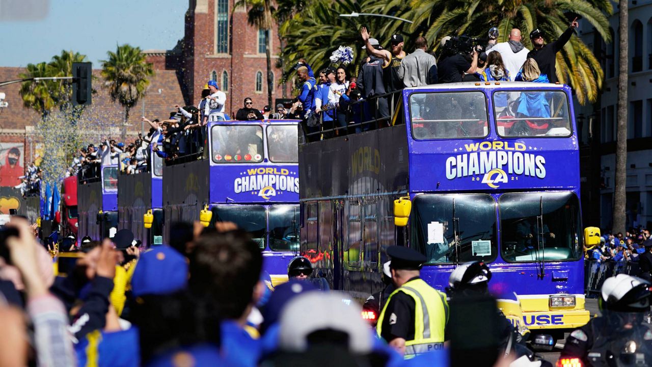 Buses carrying Los Angeles Rams players and coaches drive past fans during the team's victory parade in Los Angeles, Wednesday, Feb. 16, 2022, following their win Sunday over the Cincinnati Bengals in the NFL Super Bowl 56 football game. (AP Photo/Marcio Jose Sanchez)