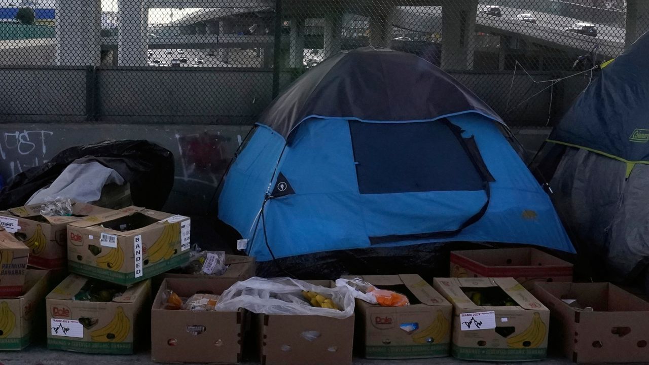 Boxes with donated fresh food sit next to tents used by the homeless on the CA-110 freeway in Los Angeles. (AP Photo/Damian Dovarganes)