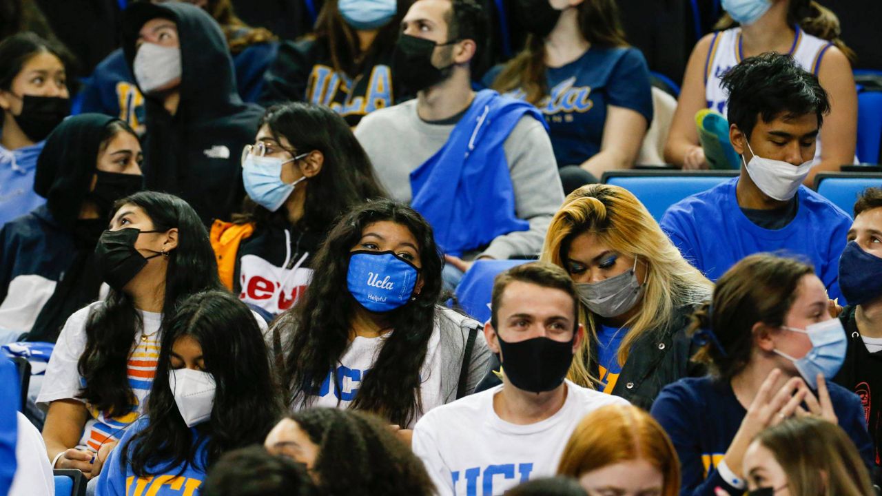 Fans wearing face masks watch during the first half of an NCAA college basketball game between Washington State and UCLA Thursday, Feb. 17, 2022, in Los Angeles. (AP Photo/Ringo H.W. Chiu)