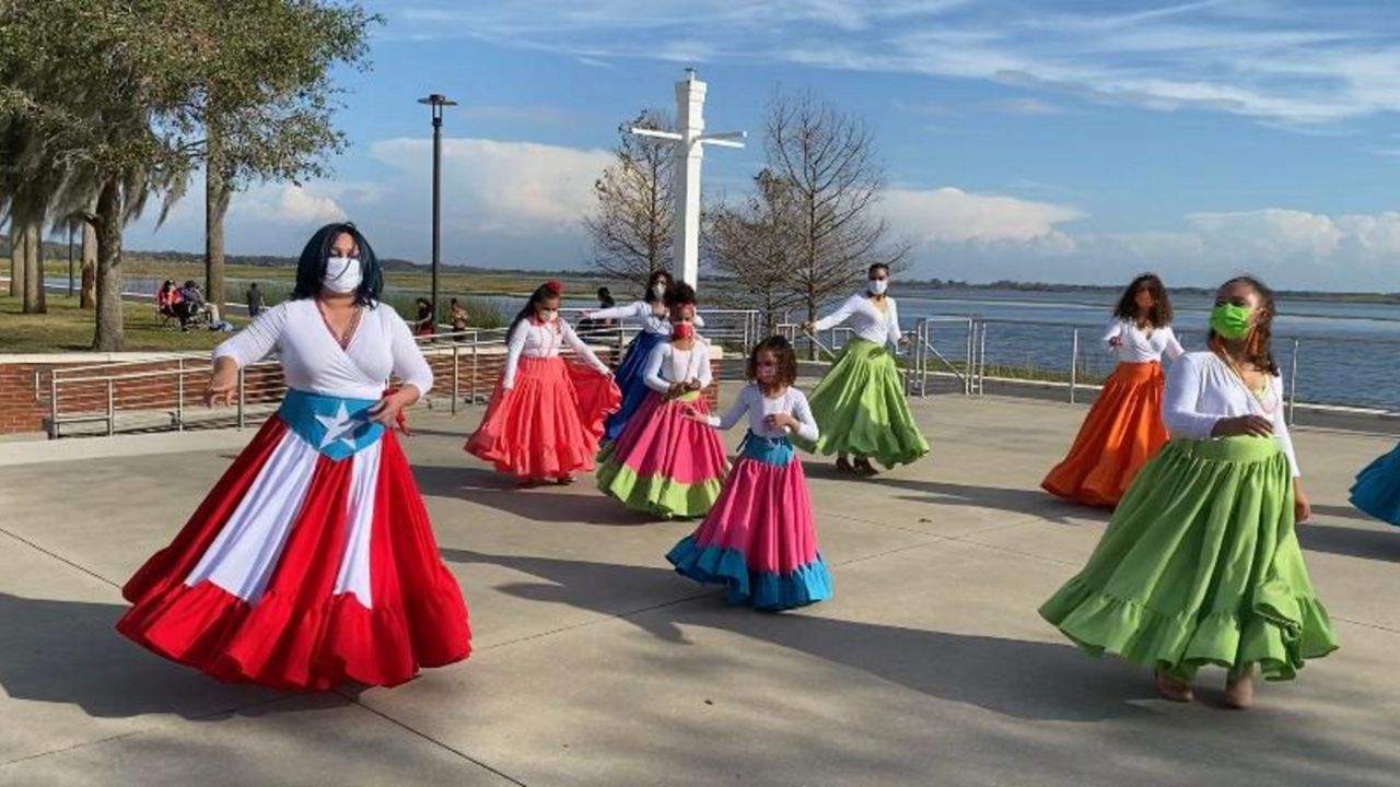 Barbara Liz Cepeda (left) leads a group of bomba dancers Saturday at Kissimmee Lakefront Park. Bomba dates to Puerto Rico’s early colonial period when enslaved Africans used it as a source of spiritual expression. (Pete Reinwald/Spectrum News 13)