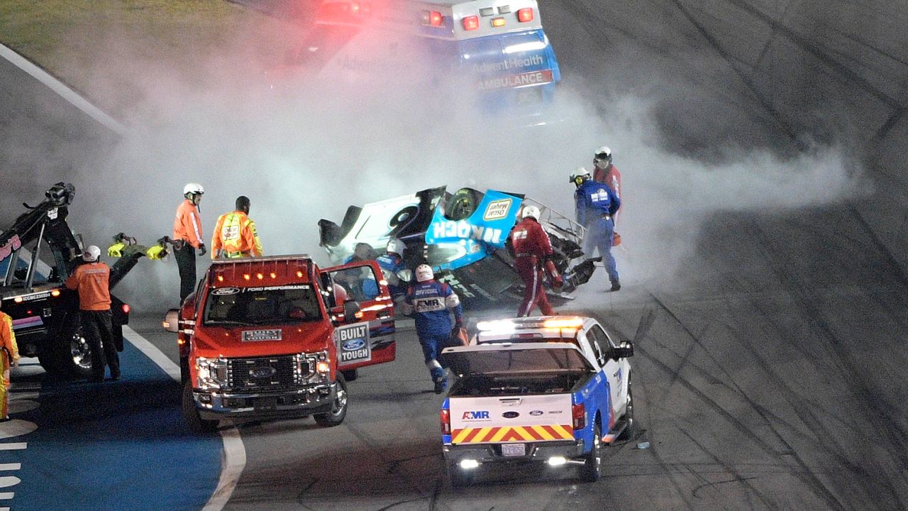 Track personnel arrive to help Ryan Newman (6) after he flipped his car on the final lap in front of the grandstands during the NASCAR Daytona 500 auto race at Daytona International Speedway, Monday, Feb. 17, 2020, in Daytona Beach, Fla. (AP Photo/Phelan M. Ebenhack)