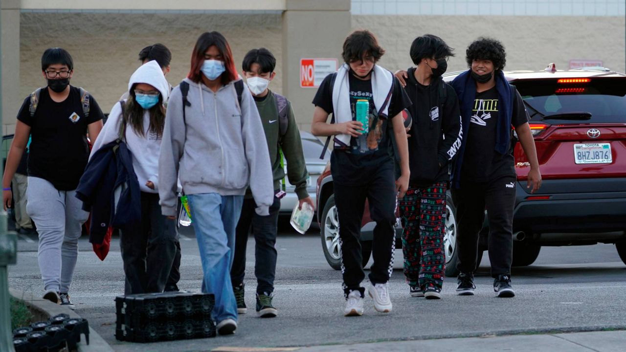 High school students wear masks outdoors in downtown Los Angeles on Feb. 18. (AP Photo/Damian Dovarganes)