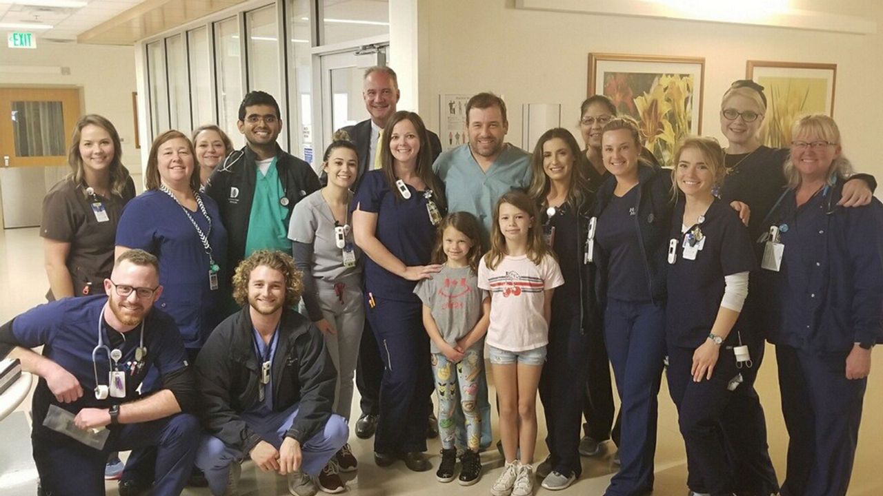 NASCAR racer Ryan Newman (center, with his daughters), poses with the clinical team at Halifax Medical Center, where he was treated after the crash during the Daytona 500. (Halifax Health)